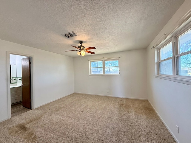 carpeted spare room featuring a textured ceiling and ceiling fan