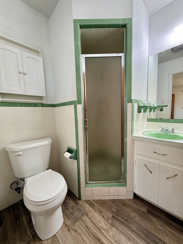 bathroom with an enclosed shower, hardwood / wood-style floors, and tile walls