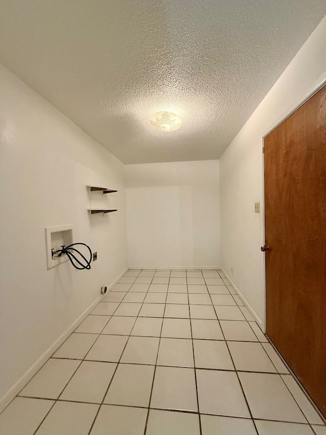 laundry area featuring light tile patterned floors, hookup for a washing machine, and a textured ceiling