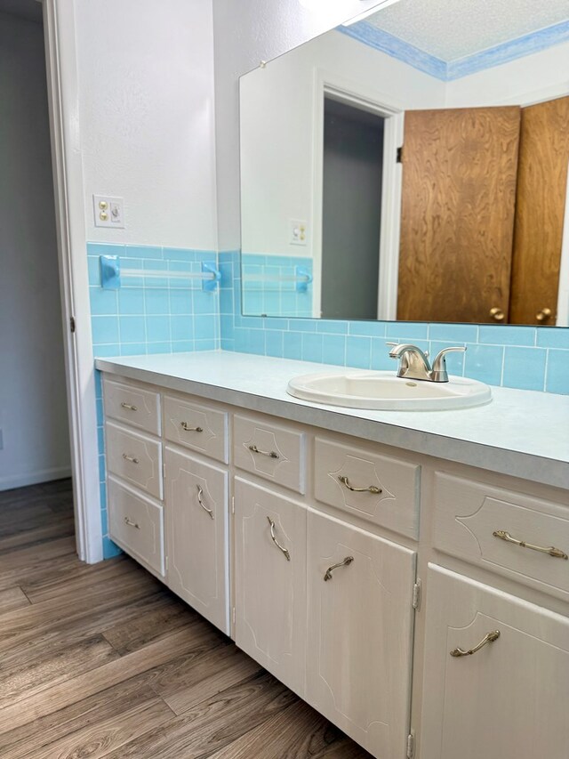 bathroom featuring wood-type flooring, tile walls, and vanity