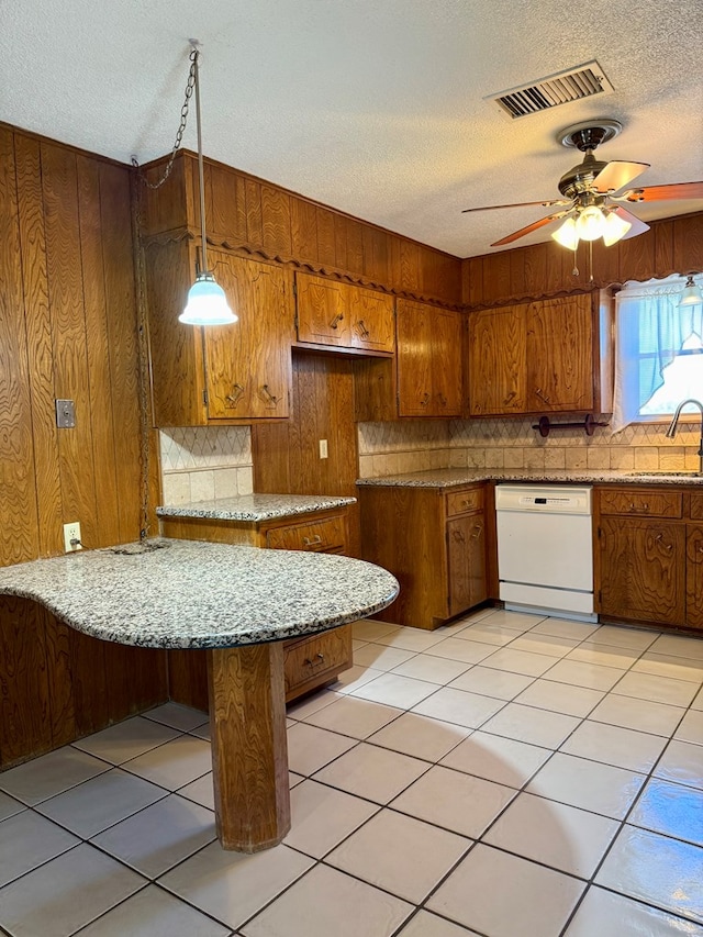 kitchen featuring light tile patterned flooring, decorative light fixtures, dishwasher, sink, and decorative backsplash