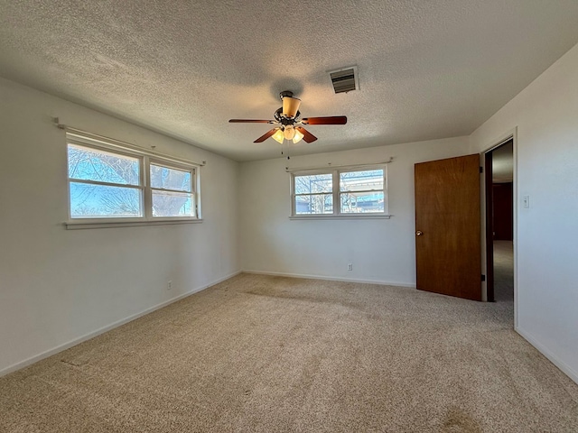 carpeted spare room featuring a textured ceiling and ceiling fan