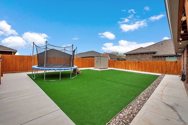 view of yard with a storage unit and a trampoline