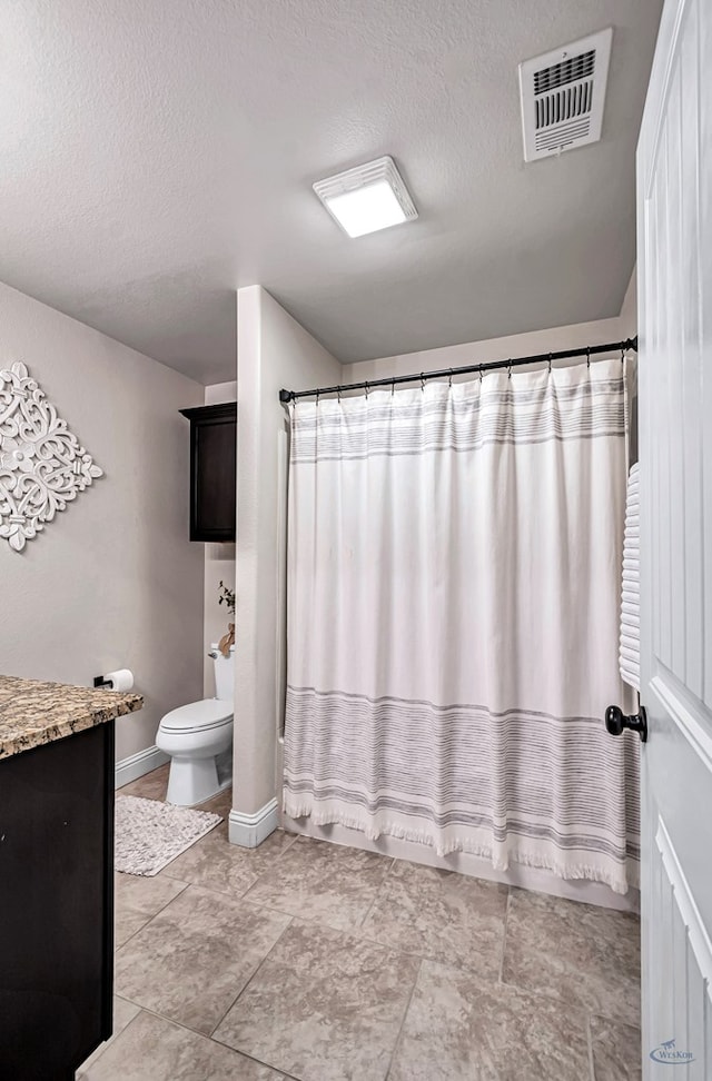 full bathroom featuring shower / bath combo with shower curtain, vanity, a textured ceiling, and toilet