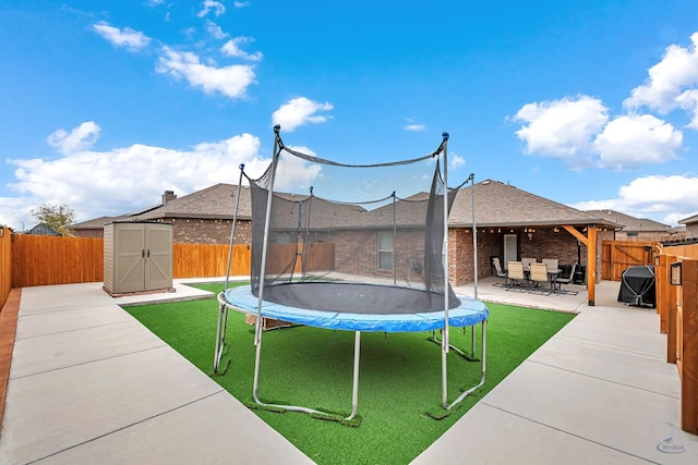 exterior space featuring a storage unit, a patio, and a trampoline