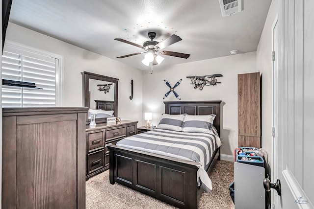 bedroom featuring a textured ceiling, ceiling fan, and light carpet