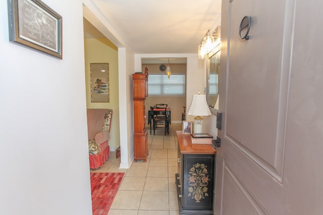 hallway featuring light tile patterned floors and baseboards