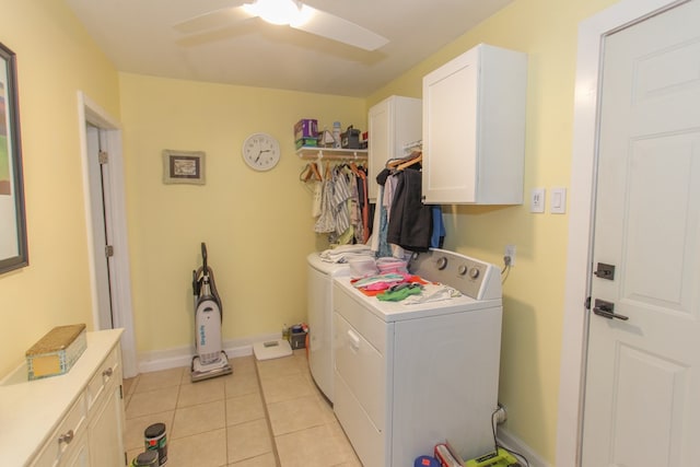 washroom featuring washing machine and dryer, cabinet space, baseboards, and light tile patterned floors