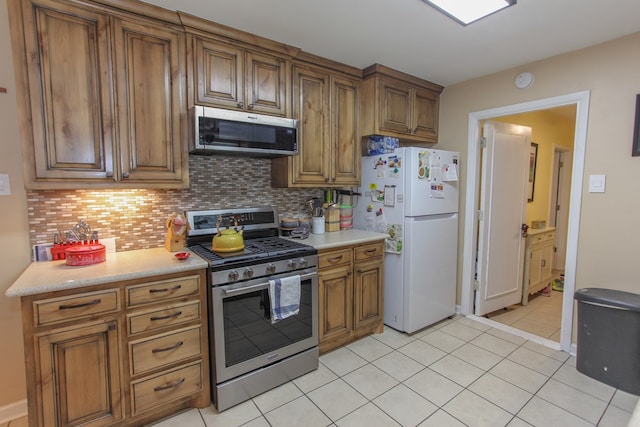 kitchen with tasteful backsplash, stainless steel appliances, and light tile patterned floors