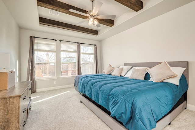 carpeted bedroom with ceiling fan, a raised ceiling, and beamed ceiling