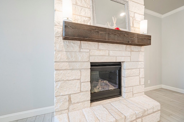 room details with ornamental molding, a stone fireplace, and hardwood / wood-style floors