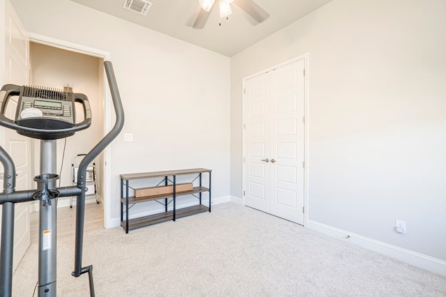 exercise room featuring light colored carpet and ceiling fan