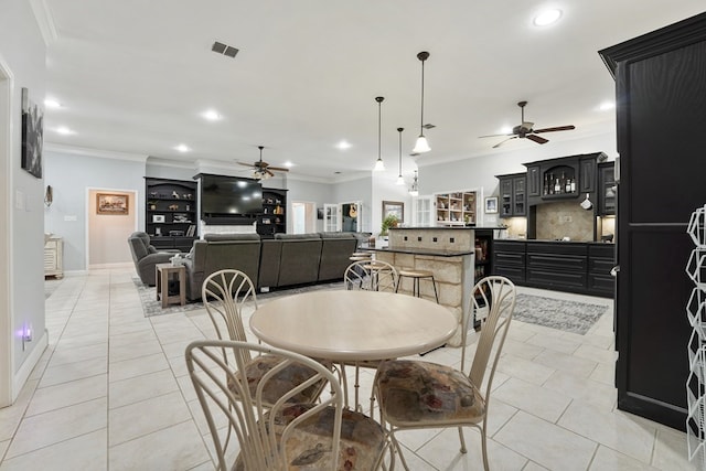 tiled dining room with bar area and ornamental molding