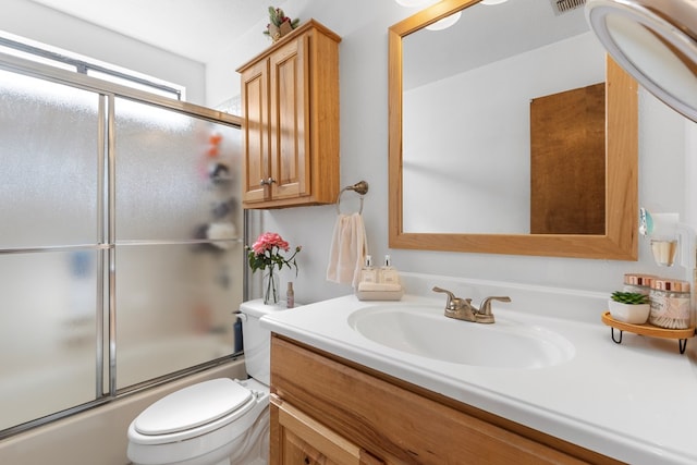 full bath with vanity, bath / shower combo with glass door, and toilet