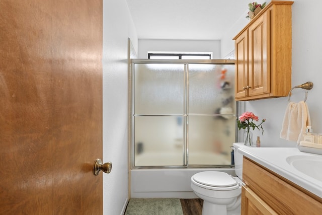 full bathroom featuring shower / bath combination with glass door, toilet, and vanity