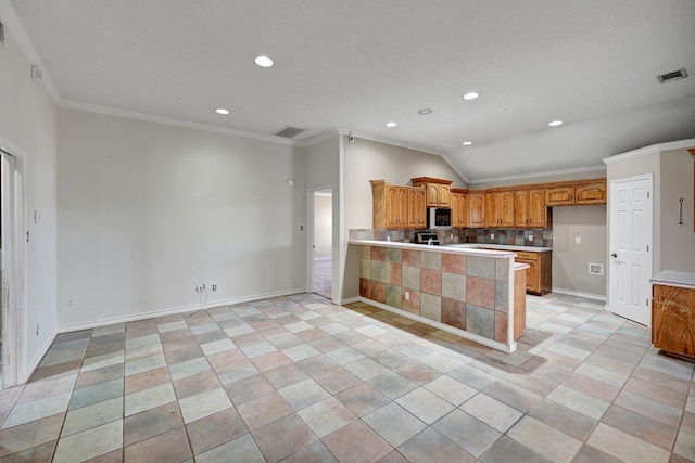 kitchen with visible vents, light countertops, stainless steel microwave, and ornamental molding