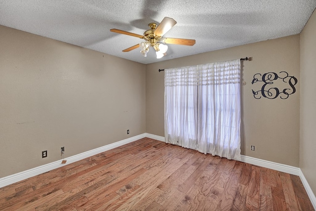 unfurnished room with a ceiling fan, a textured ceiling, baseboards, and wood finished floors