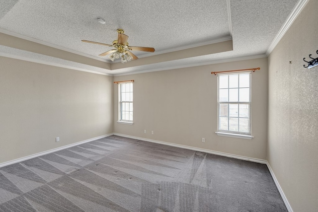 spare room featuring baseboards, a tray ceiling, a textured ceiling, crown molding, and carpet floors