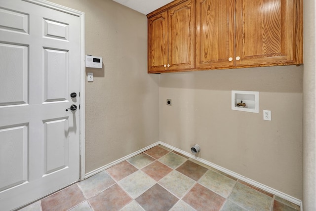 clothes washing area with cabinet space, baseboards, stone finish floor, hookup for a washing machine, and hookup for an electric dryer