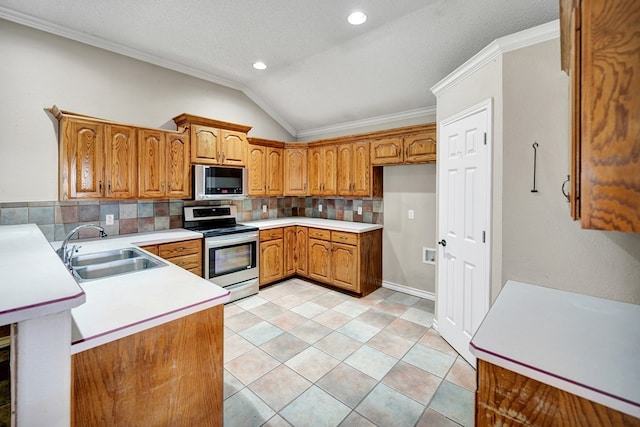 kitchen featuring vaulted ceiling, appliances with stainless steel finishes, brown cabinetry, and a sink