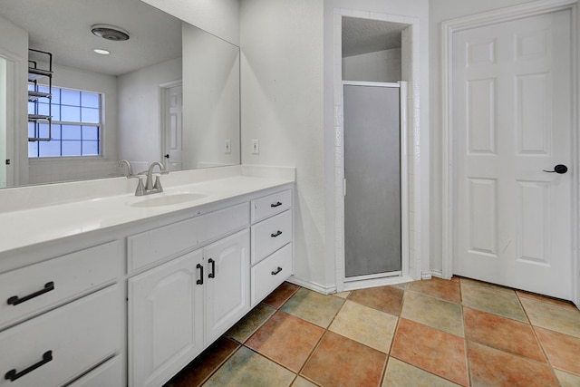 bathroom with a shower stall and vanity