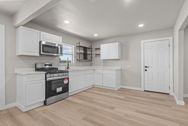 3902 Thomason Dr, Midland, TX 79703 - kitchen with appliances with stainless steel finishes, a sink, baseboards, light wood-style floors, and light countertops