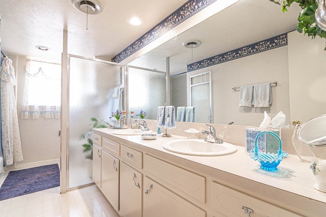 3108 Seaboard Ave, Midland, TX 79705 - bathroom featuring double vanity, a shower with door, and baseboards