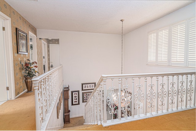 3108 Seaboard Ave, Midland, TX 79705 - hallway featuring an upstairs landing, carpet flooring, wallpapered walls, baseboards, and a textured ceiling