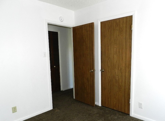 unfurnished bedroom with dark carpet