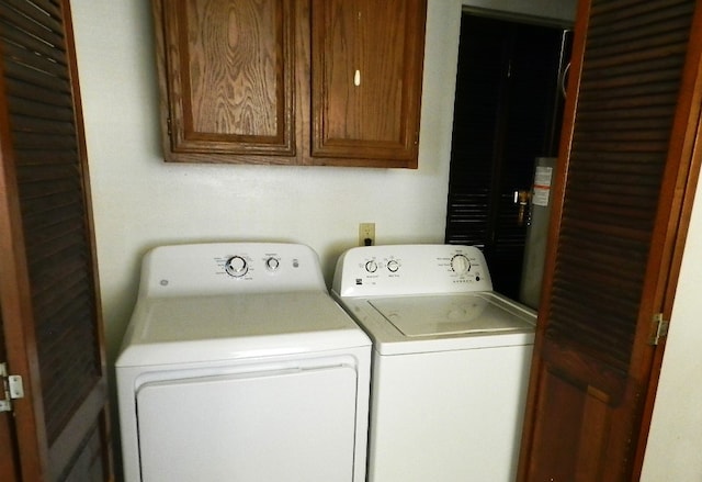 laundry area with separate washer and dryer and cabinets