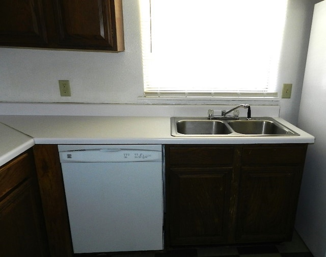 kitchen featuring white dishwasher, dark brown cabinets, and sink