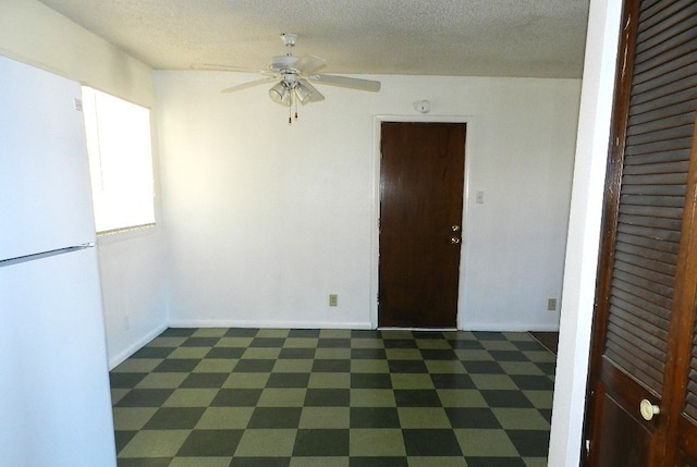 spare room featuring a textured ceiling and ceiling fan