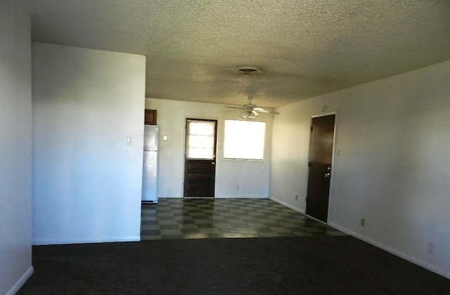 spare room with a textured ceiling and ceiling fan