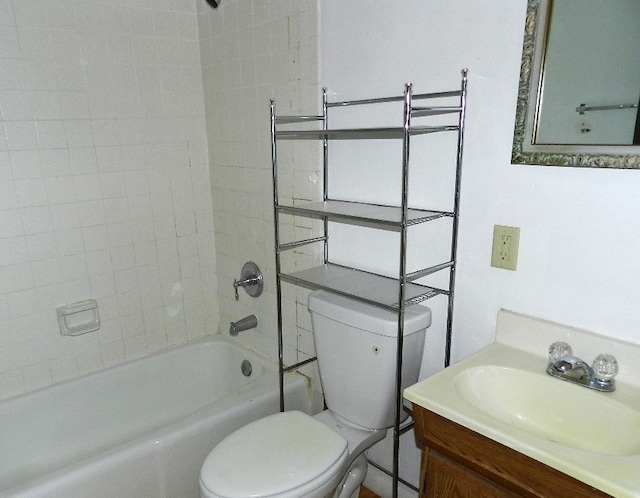 full bathroom with toilet, tiled shower / bath, and vanity