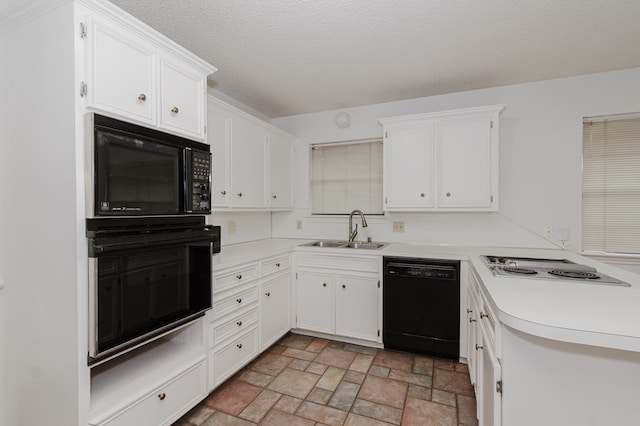 kitchen with white cabinets, black appliances, light countertops, and a sink