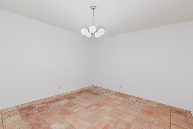 unfurnished room with baseboards and a notable chandelier