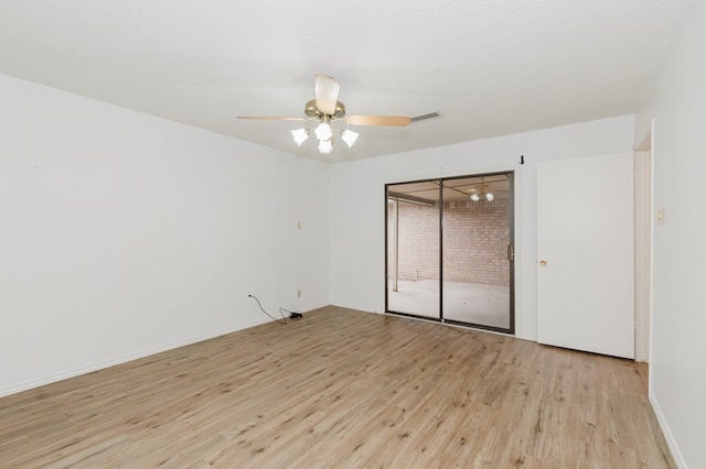 empty room featuring visible vents, a textured ceiling, light wood-style flooring, and a ceiling fan