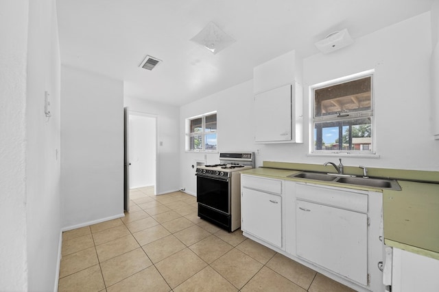 204 Acklen, Midland, TX 79703 - kitchen with range with gas stovetop, white cabinets, light tile patterned flooring, and light countertops