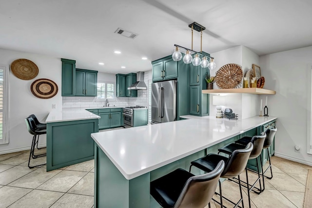 3513 Stanolind Ave, Midland, TX 79707 - kitchen with green cabinets, high end appliances, wall chimney exhaust hood, a peninsula, and backsplash