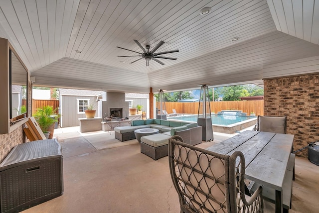 3513 Stanolind Ave, Midland, TX 79707 - fenced backyard featuring a patio, outdoor dining area, a hot tub, a ceiling fan, and an outdoor living space with a fireplace