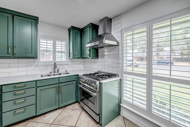 3513 Stanolind Ave, Midland, TX 79707 - kitchen featuring green cabinets, wall chimney exhaust hood, high end stainless steel range, light tile patterned flooring, and light countertops