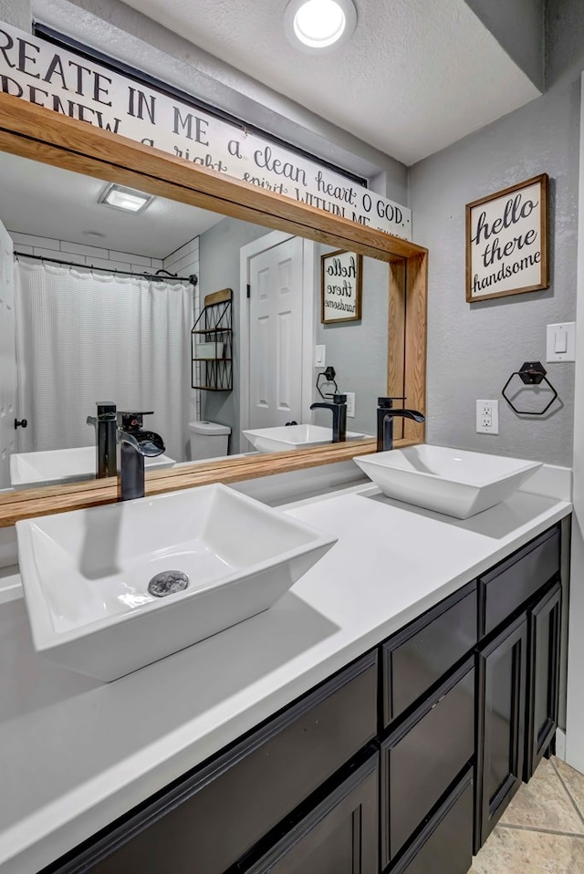 3513 Stanolind Ave, Midland, TX 79707 - bathroom featuring double vanity and a textured ceiling