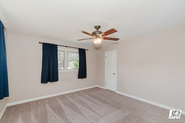 carpeted spare room with ceiling fan and baseboards