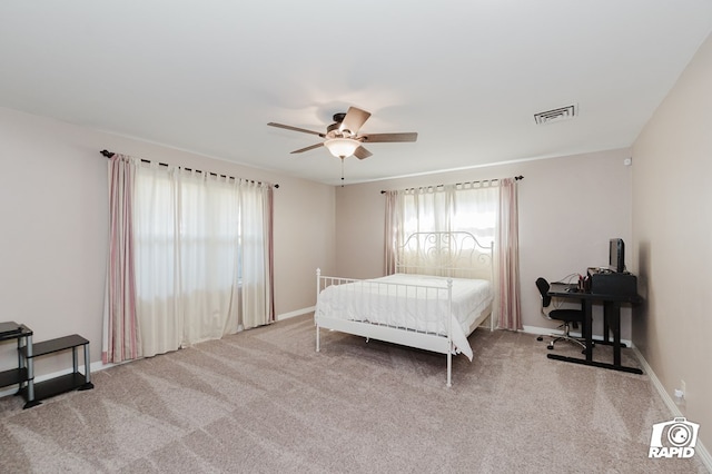 bedroom with light carpet, ceiling fan, visible vents, and baseboards