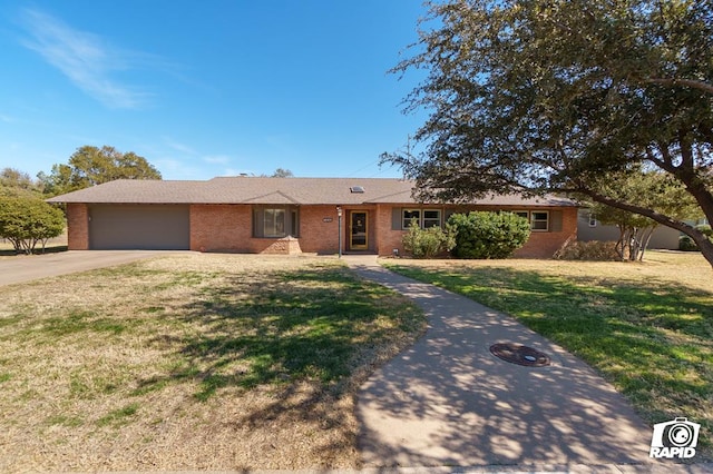 ranch-style home with a garage, driveway, a front lawn, and brick siding