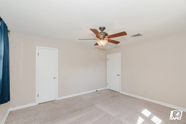 empty room featuring light carpet, visible vents, baseboards, and ceiling fan