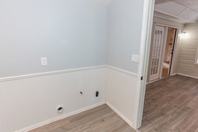 laundry room with hardwood / wood-style floors, gas dryer hookup, and wood walls