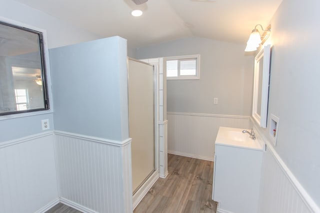 bathroom with wood-type flooring, vanity, walk in shower, and lofted ceiling