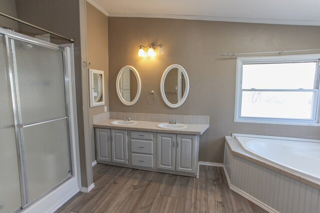 bathroom with hardwood / wood-style floors, vanity, independent shower and bath, and ornamental molding