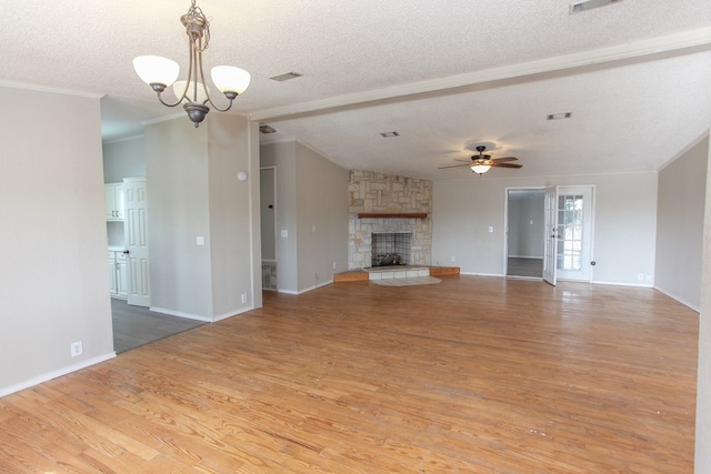 unfurnished living room featuring crown molding, a fireplace, wood-type flooring, and a textured ceiling